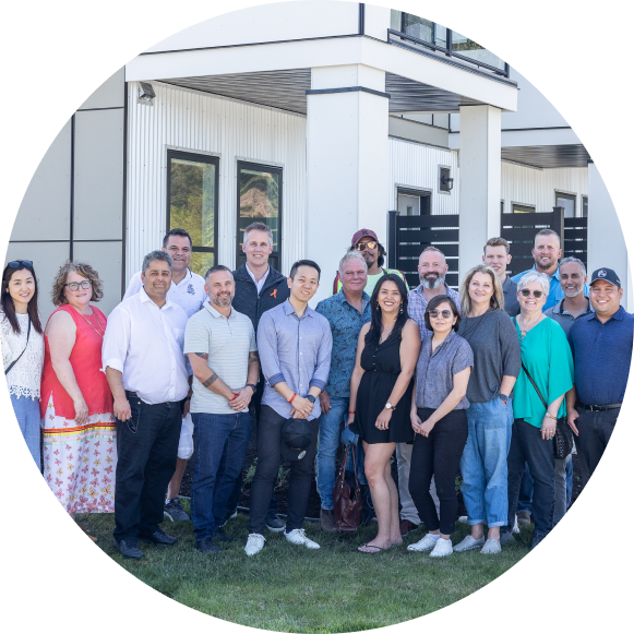 Group of several people including Seven Generations Capital team members standing in front of a development.